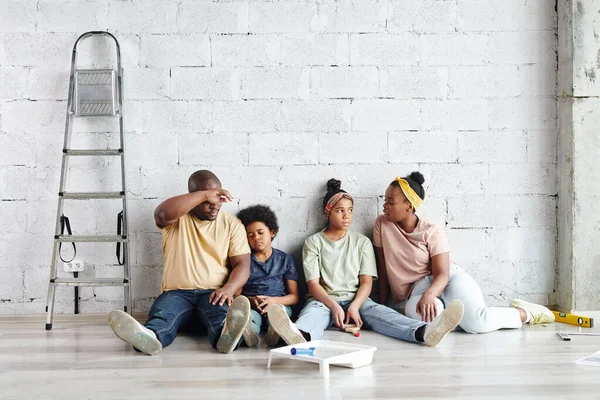 Trött Afrikansk Familj Fyra Sittande Mot Vitmålad Vägg Golvet Vardagsrummet — Stockfoto