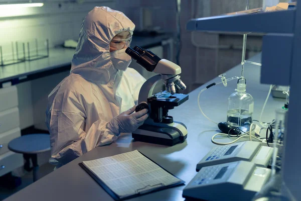 Chimico Abiti Lavoro Protettivi Esaminando Campioni Attraverso Microscopio Laboratorio — Foto Stock