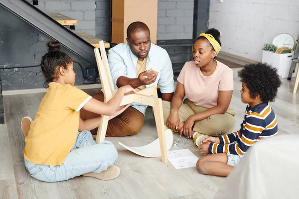 Hombre Africano Mirando Pequeña Parte Rectangular Silla Madera Mientras Consulta —  Fotos de Stock