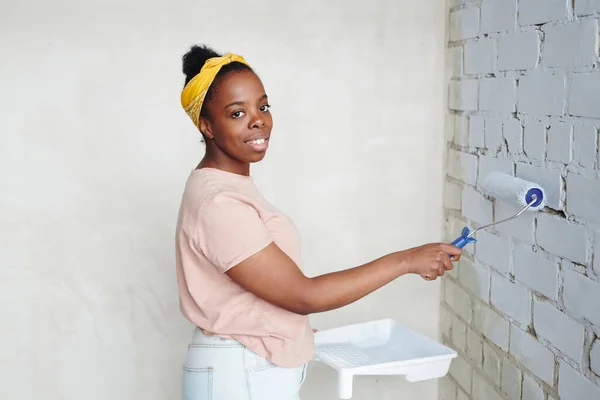 Jovem Fêmea Africana Feliz Com Paintroller Canto Frente Parede Tijolo — Fotografia de Stock