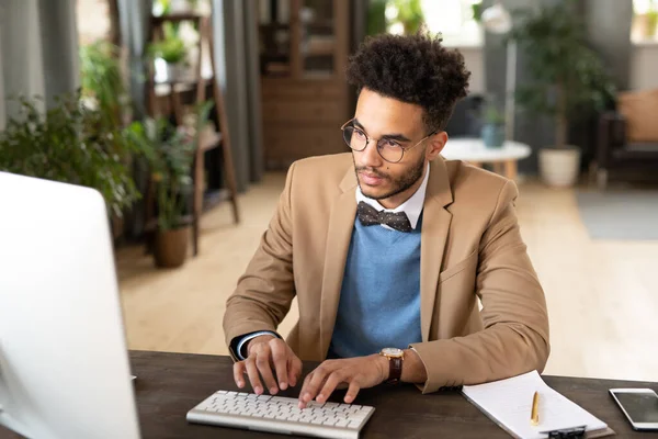 Seriöser Junger Afroamerikanischer Geschäftsmann Mit Brille Und Armbanduhr Sitzt Tisch — Stockfoto