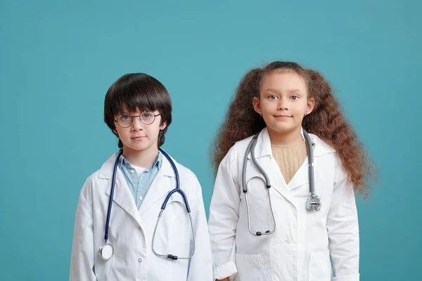 Retrato Duas Crianças Casacos Médicos Sorrindo Para Câmera Contra Fundo — Fotografia de Stock