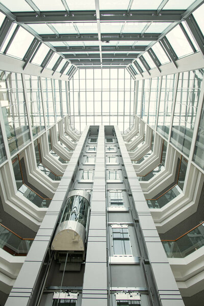 Perspective of office lobby: round-shaped roof and glassy walls in modern hall with elevator