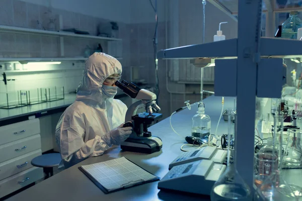 Forskare Skyddsarbetskläder Undersöker Bakterien Genom Mikroskopet Vid Bordet Labbet — Stockfoto