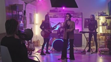 Stüdyoda müzik videosu kaydeden genç rock grubunun Slowmo 'su, müzik yapımcıları megafonla emirler verirken neon ışıkla sahnede kalıyor.