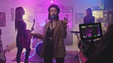 Genç bayan rock grubunun neon ışıklarıyla sahnede kalırken kaydettiği müzik videosuyla video operatörünün orta yavaşlığı.