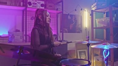 Gece kulübünde rock konserinde bateri çalan, rastalı ve gotik makyajlı havalı rock-n-roll kızı.