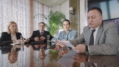 Erkek ve kadın yatırımcılardan oluşan çok ırklı bir ekibin iş ortaklarıyla iş planı ve stratejisini tartışan bir video konferansı görüntüsü.