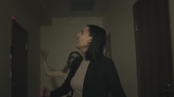 跟踪拍摄的年轻女子尖叫和逃离僵尸在走廊 — 图库视频影像