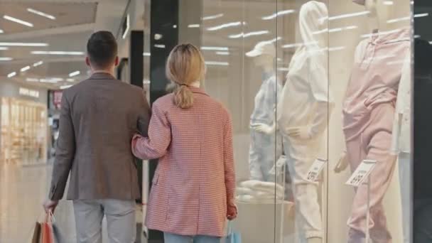 현대의 쇼핑몰에 전시된 마네킹을 쇼핑백을 스마트 부부의 — 비디오