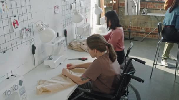 ファッションデザインスタジオで衣服を縫製する若い女性の追跡ショット — ストック動画