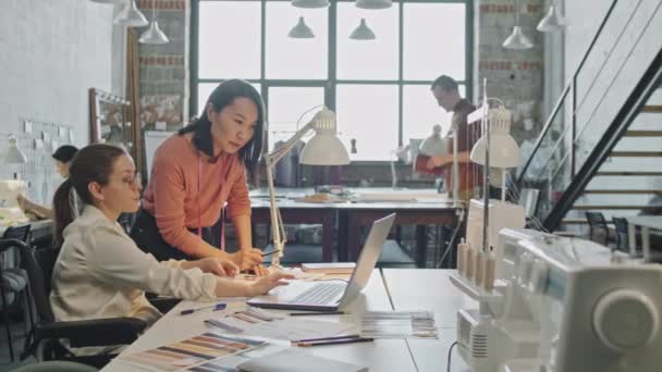 Середній Знімок Дизайнера Жіночої Моди Який Дивиться Ноутбук Обговорює Ідеї — стокове відео