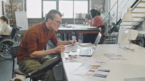 Medium Shot Male Fashion Designer Prosthetic Leg Sitting Desk Studio — Stock Video