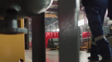 PAN dikiz görüntüsü, fabrikada çalışan yavaş kadın ve iki adam mavi üniformalı ve sarı şapkalı iki adam.