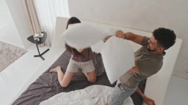 Genç ve eğlenceli Latin çiftin yataklarında yastık kavgası yaparken, sabahları evlerinde, modern minimalist tarzdaki evlerinde eğlenirken en iyi görüntü.