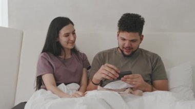 İspanyol kökenli güzel bir kadının orta boy fotoğrafı. Kocasına içinde pozitif hamilelik testi olan bir hediye kutusu veriyor. Mutlu adam yakında baba olacağını öğreniyor.
