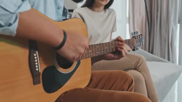 알아볼 수없을 정도로 남자가 기타를 연주하고 아름다운 아내에게 노래를 부르며 — 비디오