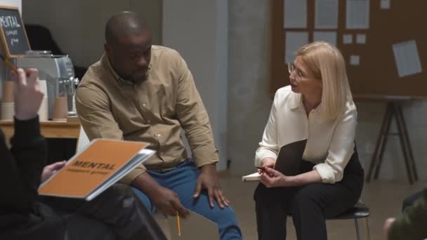 在集体治疗过程中 一个抑郁的非洲裔美国男人与支持他的女性心理学家谈论他的问题的中镜头 — 图库视频影像