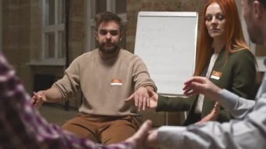 Orta halli bir grup insan el ele tutuşup terapi seanslarında birbirlerine minnettarlıklarını dile getiriyorlar.