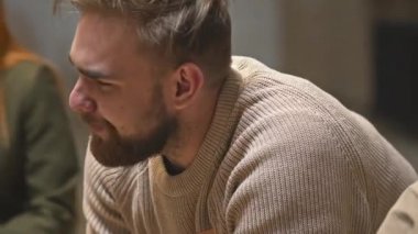 Duygusal çöküntüye uğramış, neredeyse ağlayan bir adamın yakın plan çekimi, akıl sağlığı sorunları ve grup terapisinden onu destekleyen diğer insanlar hakkında konuşurken.