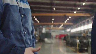 İş birliği yaptıktan sonra üniformalı, tanınmayan erkek fabrika yöneticilerinin yavaş yavaş el sıkışması.