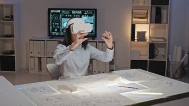 VR kulaklıklı kadın mühendisin yavaşlığını izlemek ofiste ışık masasında oturup sanal gerçeklik projesinde çalışmak.