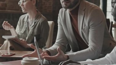 Yakışıklı iş adamlarının orta yaşlı, şık kıyafetleri ve gözlükleriyle iş ortaklarıyla modern çatı katında yan yana oturarak sohbet etmesi.