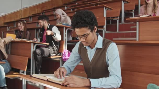 Medium Slowmo Sad Mixed Race Boy Sitting Alone Class While — Stock Video