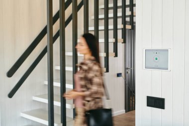 Bulanık kadın figürü evin içinde bir kapı aralığında hareket ediyor.