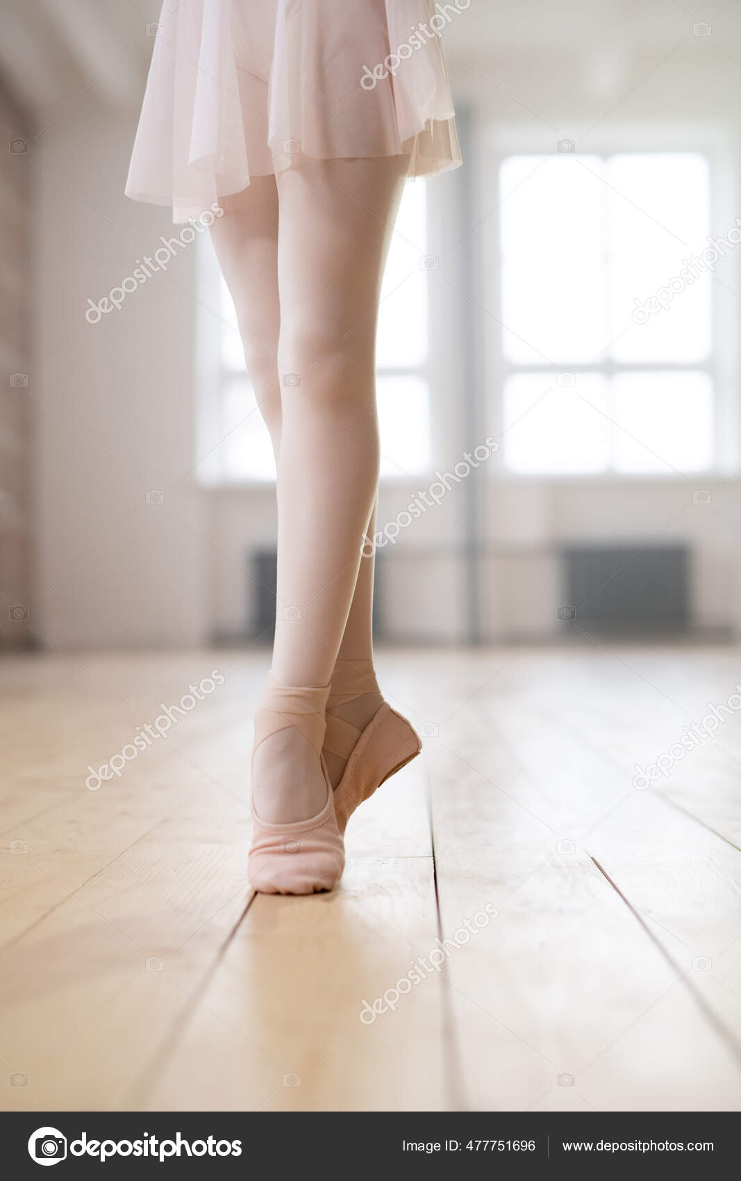Slim legs of young ballet dancer in white tights and beige silk pointe  shoes Stock Photo by Pressmaster