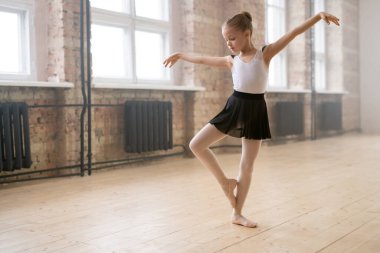 Küçük balerin stüdyoda bale eğitimi alırken dans etmeyi öğreniyor.