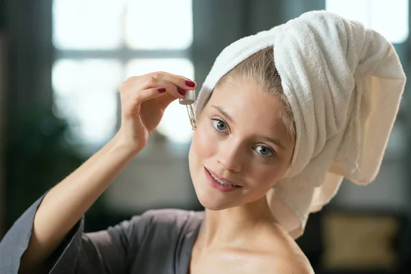 Joven Hermosa Mujer Complacida Pijama Gris Seda Aplicando Producto Cosmético —  Fotos de Stock