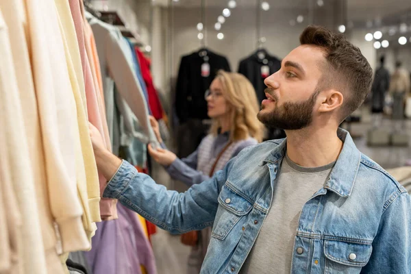 現代的な店で流行の服を見ている男と女 — ストック写真