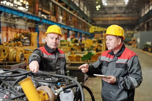 Deux Travailleurs Dans Les Casques Utilisant Tablette Discuter Travail Équipement — Photo