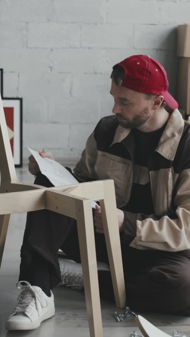 Tiro Vertical Del Manitas Uniforme Gorra Instrucciones Lectura Montaje Silla — Vídeos de Stock