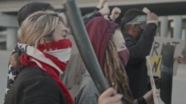 İlan veren ve protesto eden maskeli gençlerin yavaş çekimleri kalkanları olan çevik kuvvet polislerini tehdit ediyor.