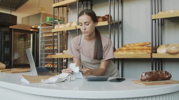 Slowmo Tracking Shot Της Νεαρής Γυναίκας Counter Attendant Κοιτάζοντας Τις — Αρχείο Βίντεο