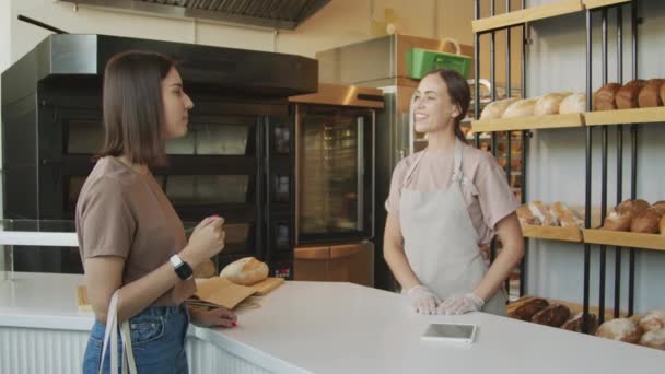 Önlüklü Eldivenli Genç Bayan Tezgahtarın Rahat Fırında Kadın Müşteriyle Konuşmasının — Stok video