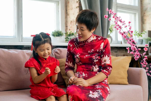 Carino piccola ragazza asiatica guardando cartolina rossa — Foto Stock