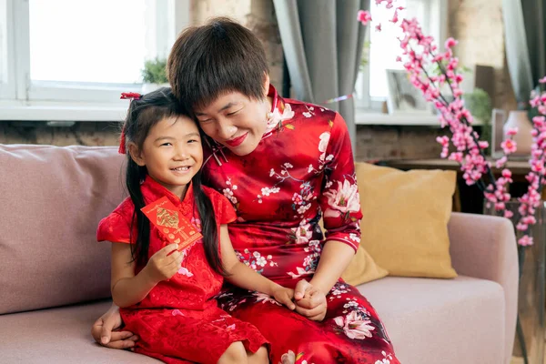 Feliz mujer china abrazando a su pequeña hija —  Fotos de Stock