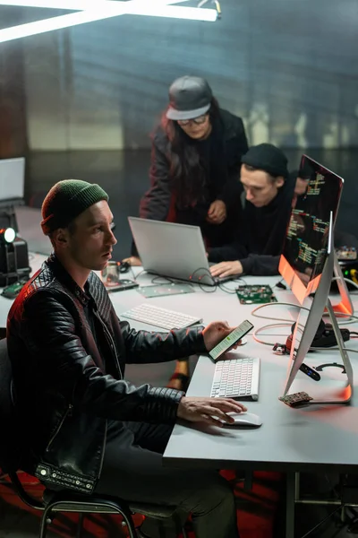 Uno dei tre truffatori utilizzando computer e smartphone — Foto Stock