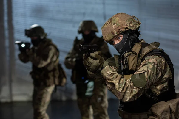 Militairen met geweren die achter criminelen aan komen — Stockfoto