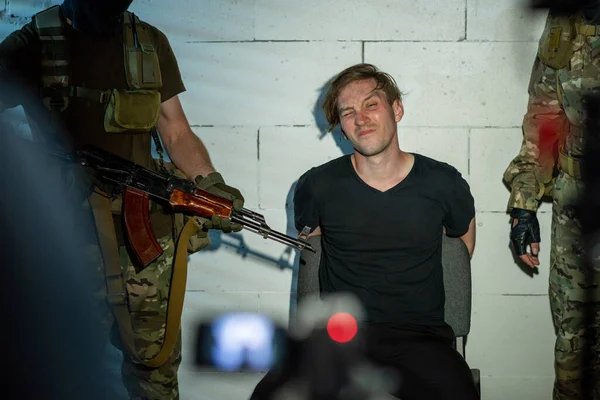 Кібер - злочинець, що сидить на стіні між двома солдатами. — стокове фото