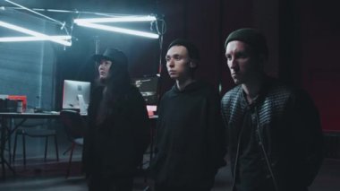 Polis tarafından tutuklandıktan sonra karanlık sığınaklarında diz çöken genç erkek ve kadın hacker 'ların el kameralı görüntüleri.