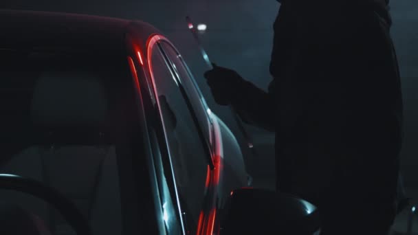 ゆっくり追跡ショットの女性泥棒でBalaclavaウェディング車のドアと取得に運転席 — ストック動画