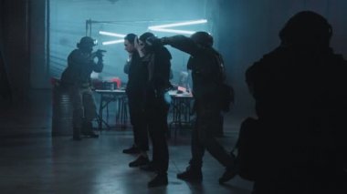 Diğer subaylar karanlık sığınaklarını korurken Özel Kuvvetler memurunun hackerları tutuklarkenki yavaş çekimleri.