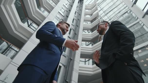 近代的なオフィスで屋内に立つ民事裁判所の成功後 彼の弁護士に握手成熟したビジネスマンの低角度ショット — ストック動画
