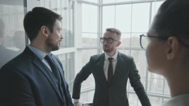 Cam asansörle aşağı inerken üç genç erkek ve kadın avukattan oluşan bir ekip ya da iş ortaklarından oluşan orta boy bir yavaşlama. Büyük bir şirkette birlikte çalışıyorlar.