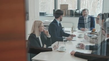 Ofis odasında avukatlarla konferans yapan iş adamlarının orta büyüklükteki PAN görüntüsü.