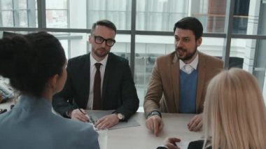 Profesyonel avukatların toplantı masasında birlikte oturup hukuki davaları tartışırken orta boy bir fotoğrafı.